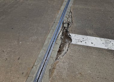 İki genişletilebilir beton gövdenin güvenli bağlantısı için çatı inşaatı veya köprü genişletme eklemleri. Metal şeritte kauçuk eklem. Donmuş beton kaldırımın tamiri. yama ve değirmenleme