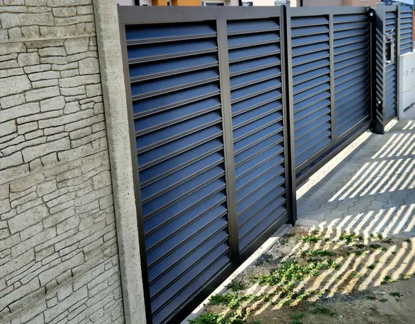 Sürgülü kapı kendi kendine katlanıyor. Küçük alan, kapının sokaktan girişteki küçük bir avluya monte edilmesini gerektiriyor. Alüminyum levhalar, taş