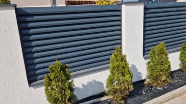 Beton bloklardan oluşan çitin metal dolguları. Metal bir alüminyum çit bahçede mahremiyet sağlayacak. Yatay kirişler iyi korunuyor. Çiçek tarhı, daimi, 