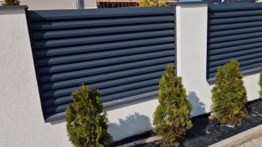 Beton bloklardan oluşan çitin metal dolguları. Metal bir alüminyum çit bahçede mahremiyet sağlayacak. Yatay kirişler iyi korunuyor. Çiçek tarhı, daimi, 