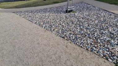 Yollar ve şeritler arasında bölünmüş bir adası olan yayalar ve bisikletçiler için gezinti alanı, asfalta boya püskürtülmüş yol işaretleri. Tekerlek, ok ve üçgen. Lüks kaplıca, harman, ahşap bank, 