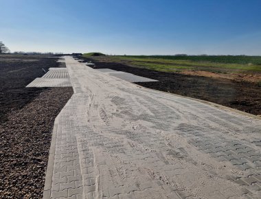 Yerli topraklarda inşaat. Geliştirici, tarlalara parselleme yapan ağlar ve asfalt yollar getirecek. Çok minimalist bir otopark.