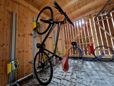 Noktalı cam çatılı bisiklet parkı. Bükülmüş gri borulardan, şehir parkındaki metal saplara bağlı gri sertleştirilmiş camlara kadar. plastik