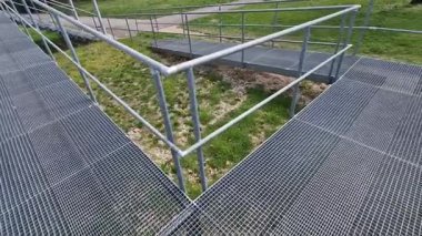 metal railings and metal grid on the floor. instead of stairs, there is a ramp for wheelchair users, a net, galvanized material. wheelchair lift. residential building, hospital entrance, senior, 