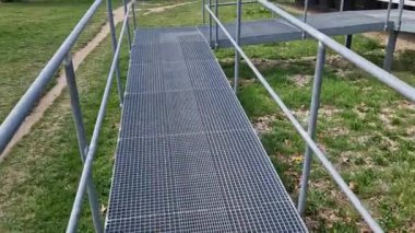 metal railings and metal grid on the floor. instead of stairs, there is a ramp for wheelchair users, a net, galvanized material. wheelchair lift. residential building, hospital entrance, senior, 