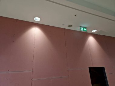 Alışveriş merkezinin ön duvarında tavan lambası var. Mağaza yenileniyor ve pencere alçıdan bir duvarla kaplı.