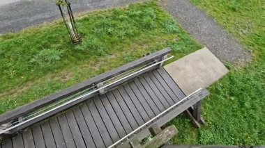 Yaşlılar ve hareketsizler için bariyersiz erişimi olan meşe kütükleri ve kalaslardan yapılmış bir gözetleme kulesi platformu. Tekerlekli sandalye rampası Metal parmaklıklar paslanmaz çelik cilalı tüp