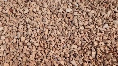 Adam elinde bir taş ya da çakıl numunesi tutuyor. Taş ocağından gelen beyaz mermer çakıl ve gri kahverengi çakıl taşları. örnek