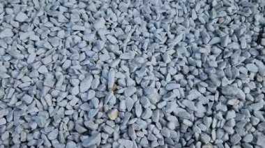 Adam elinde bir taş ya da çakıl numunesi tutuyor. Taş ocağından gelen beyaz mermer çakıl ve gri kahverengi çakıl taşları. örnek