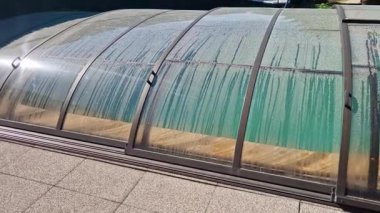 Katlanan havuz çatısı. Alüminyum ve pleksiglass kapağı raylarda çalışır. Havuzu çevreden kirden korur ve ısı sızıntısını önler ve güneşten ısı toplamaya yardımcı olur.