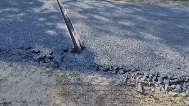 Dağlardaki asfalt yolun yenilenmesi. Hendekler, metal kanallardan akan suyu yavaşlatmak için taşlarla dolu. Kaldırım bej çakıl ile güçlendirilmiş.