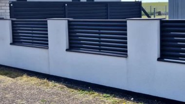 Beton bloklardan oluşan çitin metal dolguları. Metal bir alüminyum çit bahçede mahremiyet sağlayacak. Yatay kirişler iyi korunuyor. Tuji 'den yapılmış bir çit koruma sağlar.