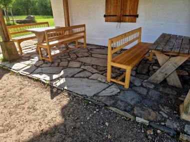 Atıştırmalıkları olan ve otlaklarda şarapla dinlenen turistler için terası olan bir kır evi. Ahşap banklar ve masalarla taşra tarzı. Yanmış kiremitlerden yapılmış gölgeli çatı