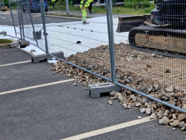 Bu koridoru geçici olarak kullanması gereken kaldırımlar ya da kaldırımlar, çalışan makinelerden ya da inşaat trafiğinden zarar görmemek için çakıl ve çelik levhalardan oluşmaktadır.