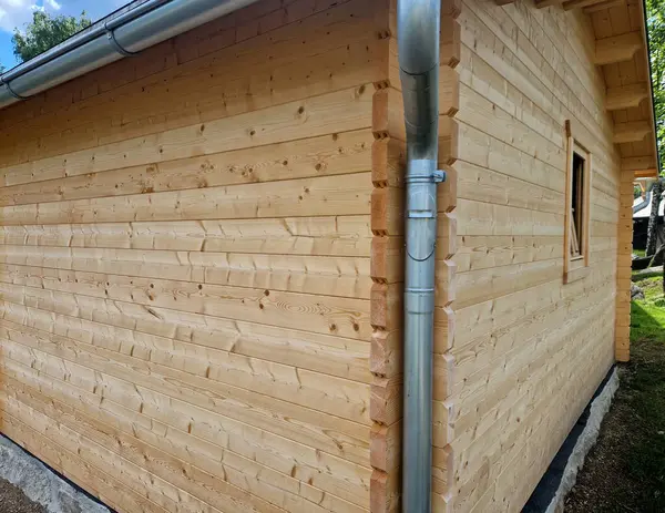 Ahşap bir kulübedeki su oluğu bir boru ve drenaj kanalıyla donatılmıştır. Metal oluk katlanır ve su kenardan bir konteynıra akar..