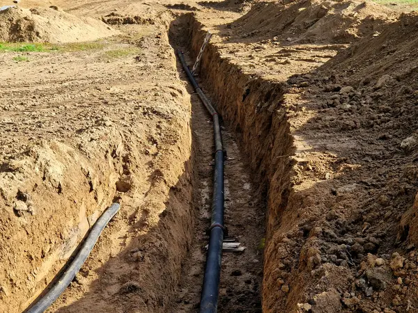 Dağlarda kalın duvarlı bir boru için kazı. Yeraltında buzsuz bir derinlikte su nakli. Geliştirme fonlarından devlet sübvansiyonlarıyla yenileme. geçici köprü