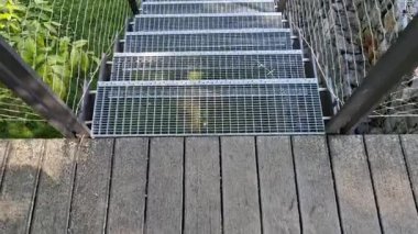 Yüksek dayanıklılığı olan taştan otoparkın yanında, galvanize çelik zemin ızgarası ve parmaklıklar altında bile dik bir merdiven inşa edilmiş. Çitin üstündeki Gabion. koridor, çiçek tarhı, kablo