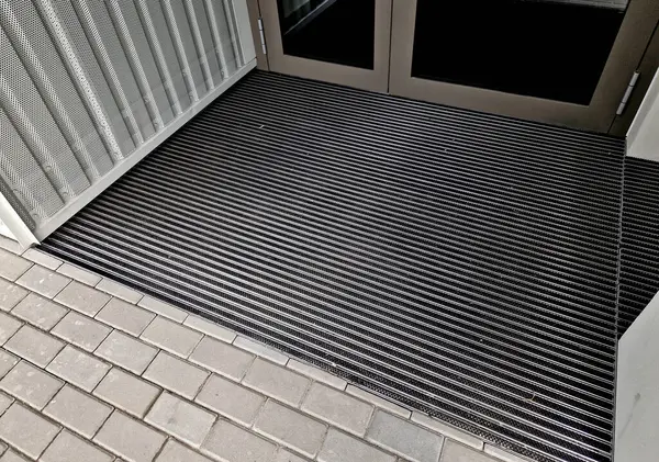 Giriş kulesi binası. Ahşap pergolu bir ofis binası. Tahtalarla birlikte temizleme bezi. Paspas. Profesyonel endüstriyel tasarım okulunda çeşitli kabalıkların plastik fırçaları, bakım