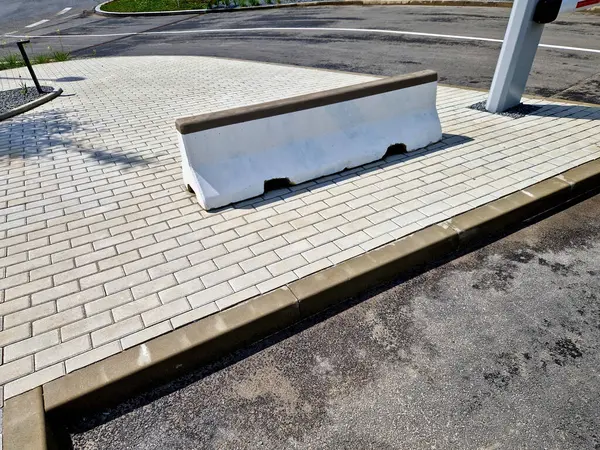 Asfalt kaldırımdaki çimen küplerini korumak için beton bariyerler. Disiplinsiz sürücüler park engelini aşamaz ve off-road 'a girmek için para ödemek zorundalar.