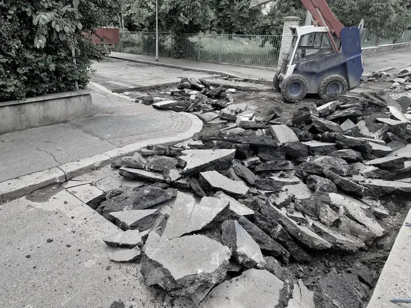 Patlayıcı çekiçle yol yüzeyini kesiyor. Çekiç parçalara ayrılır ve ezici onları öğütüp geri dönüştürülmüş malzemeye dönüştürür. Trafik ihlali olmadan onar