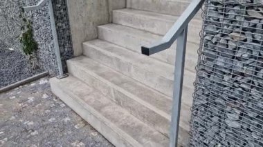 Yüksek dayanıklılığı olan taştan otoparkın yanında, galvanize çelik zemin ızgarası ve parmaklıklar altında bile dik bir merdiven inşa edilmiş. Çitin üstündeki Gabion. koridor, çiçek tarhı
