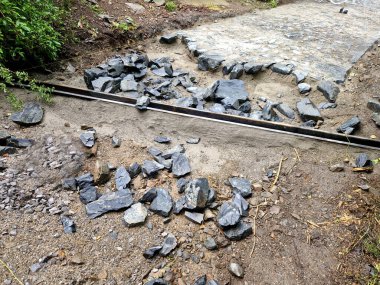 Ormandaki harman döşemenin boşaltılması bej rengi transvers metal oluklar suyu hendekte asfaltlanmış nehir yatağına boşaltıyor.