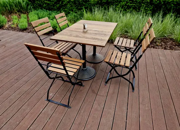Terastaki ahşap döşemeli masa metal çerçeveli ve sandalyeler katlanabilir, çimen, çerçeve