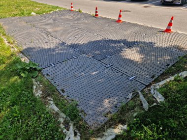 Asfalt yolların ya da kaldırımların çalışan makinelerden ya da ağır inşaatlardan zarar görmemesi için bu koridorun geçici olarak kullanılması gereken kauçuk bir döşek, kayma önleyici paspas, park yolu.