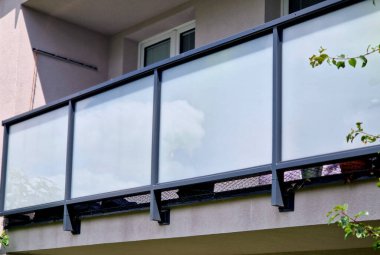 Metal paslanmaz çelik saplarla tutturulmuş cam panellerden oluşan lüks bir evin parmaklıkları. Havalı bir izlenim veriyor. Sera terası penceresinde cilalanmış metal kaplama, yansıma, iki, yapıştırıcı.