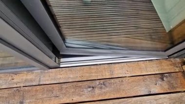 Binanın girişindeki endüstriyel paspas temizleme bölgeleri. Siyah plastik metal bir adam. Kapıyı açıyor ve içeri giriyor.