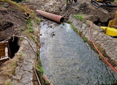 Nehrin yarısının boruya dönüştüğü sel kontrol önlemleri. Gevşek topraktan yapılmış geçici bir set. Taş bloklar betona konur ve hava manzarası yaratır.