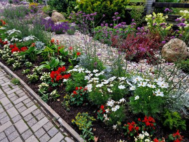 Renkli bir çiçek tarhı, çiçek açan bir kaç taş ve çakıl taşı, spa oteline iyimser bir çayırlık girişi yaratıyor.