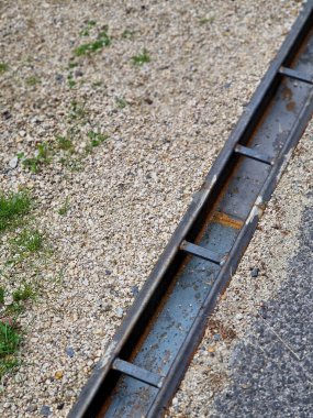 Patikanın karşısında, kanalizasyon borularını birbirine bağlayan metal bir kanal var. Su yüzeyden kanalizasyona, oradan da yağmur kanalizasyonuna çekilir.