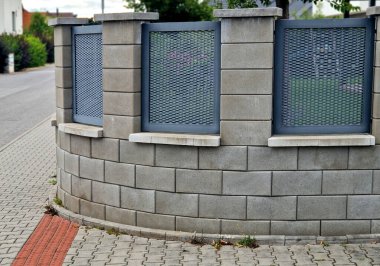 Genişletilmiş metal levha eskrimi. Galvanize parmaklıklardan yapılmış çok dayanıklı parmaklıklar. Süslü otların şeridi mekana insafsız bir bakış kazandırıyor. Öğütücü olarak yarı saydam