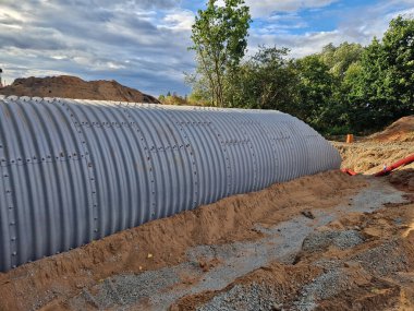 Oluklu demir tünel, yolun altındaki bir akarsu üzerinde köprü görevi görecek. Parçalardan çıkan vida borulardan yapılmış hızlı bir çözüm. Siviller için bomba ve füze sığınağı inşa ediliyor