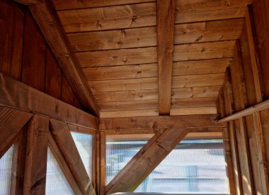 Evin duvarı dikey yarasalarla birlikte polikarbonattan yapılmıştır. Ahşap kaplı dağ turist kulübesi ve otobüs durağında bekleyen kalaslardan oluşan bir bank. reklam marangozu