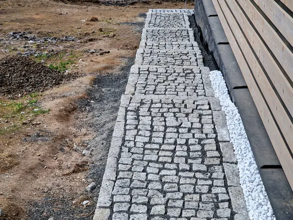 Dağlardaki kır evi boyunca yürüme yolu. Çakıl yatağında taş döşeme işi