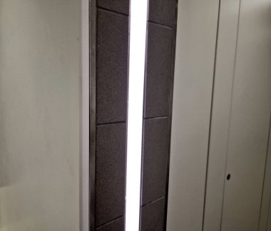 frame molding door jamb in bathroom. light strip recessed between entrance tiles