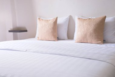 Beyaz yatak odası, dekor fikri ve tasarımı, ev dekorasyonu. Açık kahverengi yastık kenarı görünümü