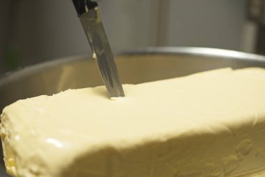 Tereyağı kalıbı bit kasesinde, üzerinde bir bıçakla..