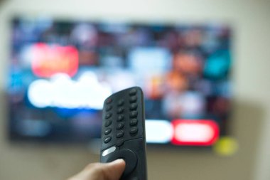 Uzaktan kumandayla el, TV dizilerini servis platformundan değiştirme. Evde eğlenmenin yeni bir yolu..