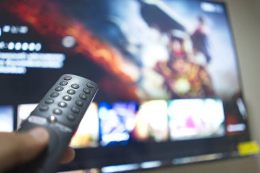 Uzaktan kumandayla el, TV dizilerini servis platformundan değiştirme. Evde eğlenmenin yeni bir yolu..