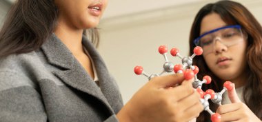 BTMM eğitim konsepti. Laboratuvardaki Asyalı çocuklar molekül modeli üzerinde deney yapıyorlar. Fen, Teknoloji, Mühendislik ve Matematik 'in de dahil olduğu bir sınıftaki yeni eğitim sistemi.