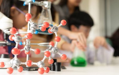 BTMM eğitim konsepti. Laboratuvardaki Asyalı çocuklar molekül modeli üzerinde deney yapıyorlar. Fen, Teknoloji, Mühendislik ve Matematik 'in de dahil olduğu bir sınıftaki yeni eğitim sistemi.