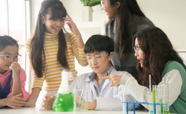 BTMM eğitim konsepti. Laboratuvardaki Asyalı çocuklar kimya deney şişesiyle deney yapıyorlar. Fen, Teknoloji, Mühendislik ve Matematik 'in de dahil olduğu bir sınıftaki yeni eğitim sistemi.