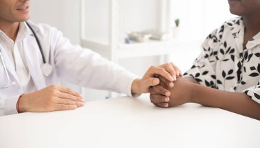 Hastanede steteskopu olan Afrikalı Amerikalı bir hastayı muayene eden İspanyol doktor. Sağlık hizmetleri tıbbi teşhisi ve incelemesi.