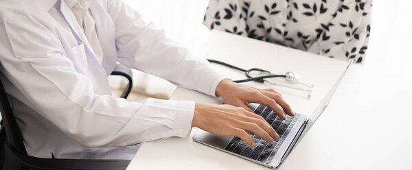 Physician check-up patient with stethoscope at the hospital. Healthcare medical diagnosis and examining on the laptop. Copy space background.