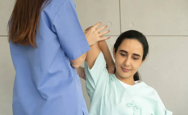 Female Caucasian physiotherapist rehabilitation with Hispanic patient. The doctor doing stretching on patient\'s pain body for therapy and recovery healthcare.