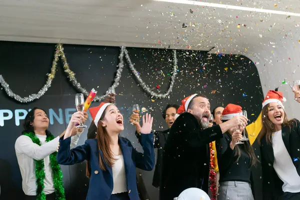 Happy new year 2024 !! A group of diverse business people and colleagues having fun together at a business New Year party. A teamwork celebration of a successful target. Confetti and wine glasses enjoyment.