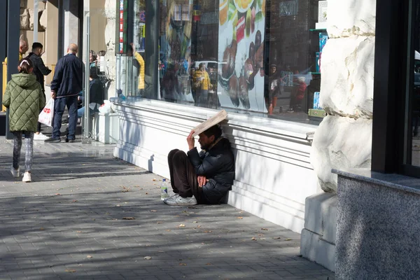 基希讷乌 摩尔多瓦 2022年10月15日 一个人祈求施舍 一个留着胡子的男人坐在他的后腿上 坐在一块纸板后面 请求施舍 摩尔多瓦的社会问题 无家可归者和乞丐 — 图库照片